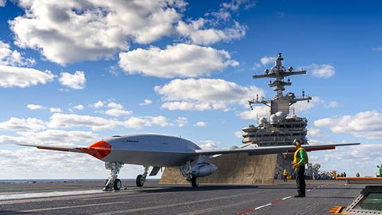 ALL SET: T1, the MQ-25 test aircraft, is connected to the catapult with the jet blast deflector up on the USS George H.W. Bush flight deck. The carrier-based demonstration showed how a new remote-controlled deck handling system can move the unmanned aircraft into the catapult. (Photo: Tim Reinhart/Boeing)