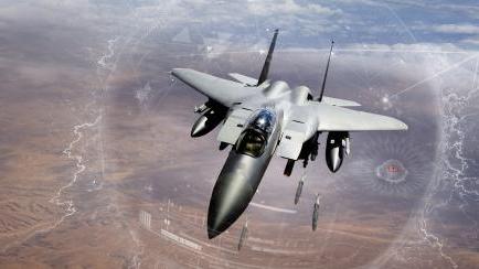 An F-15 flies over a desert scenario. An artist’s overlay depicts GPS capabilities.